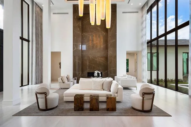 Brown marble fireplace with pendant chandelier and floor-to-ceiling windows