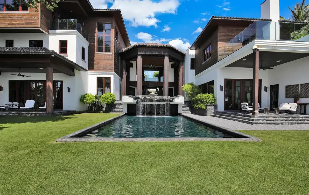 Aerial view of thatched pavilion, pool with rock waterfall, and Intracoastal
