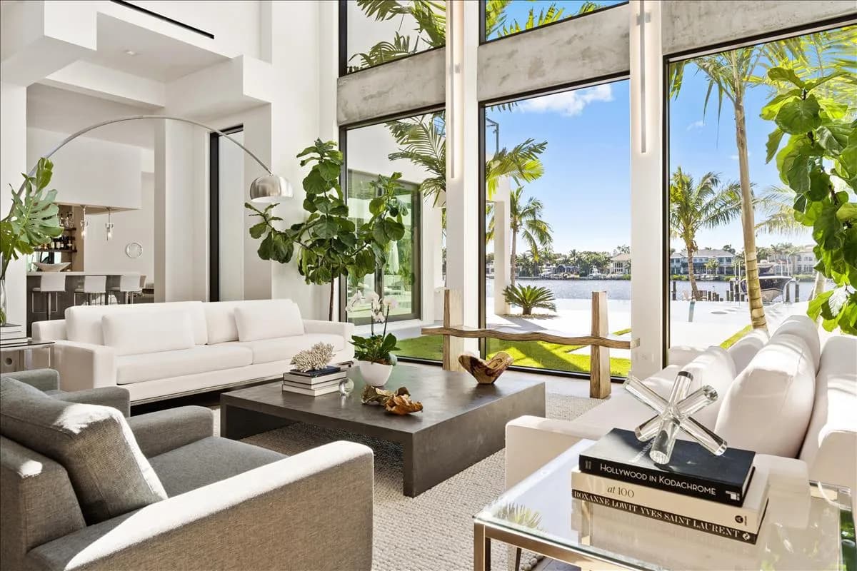 Double-height living room with floor-to-ceiling windows and river views